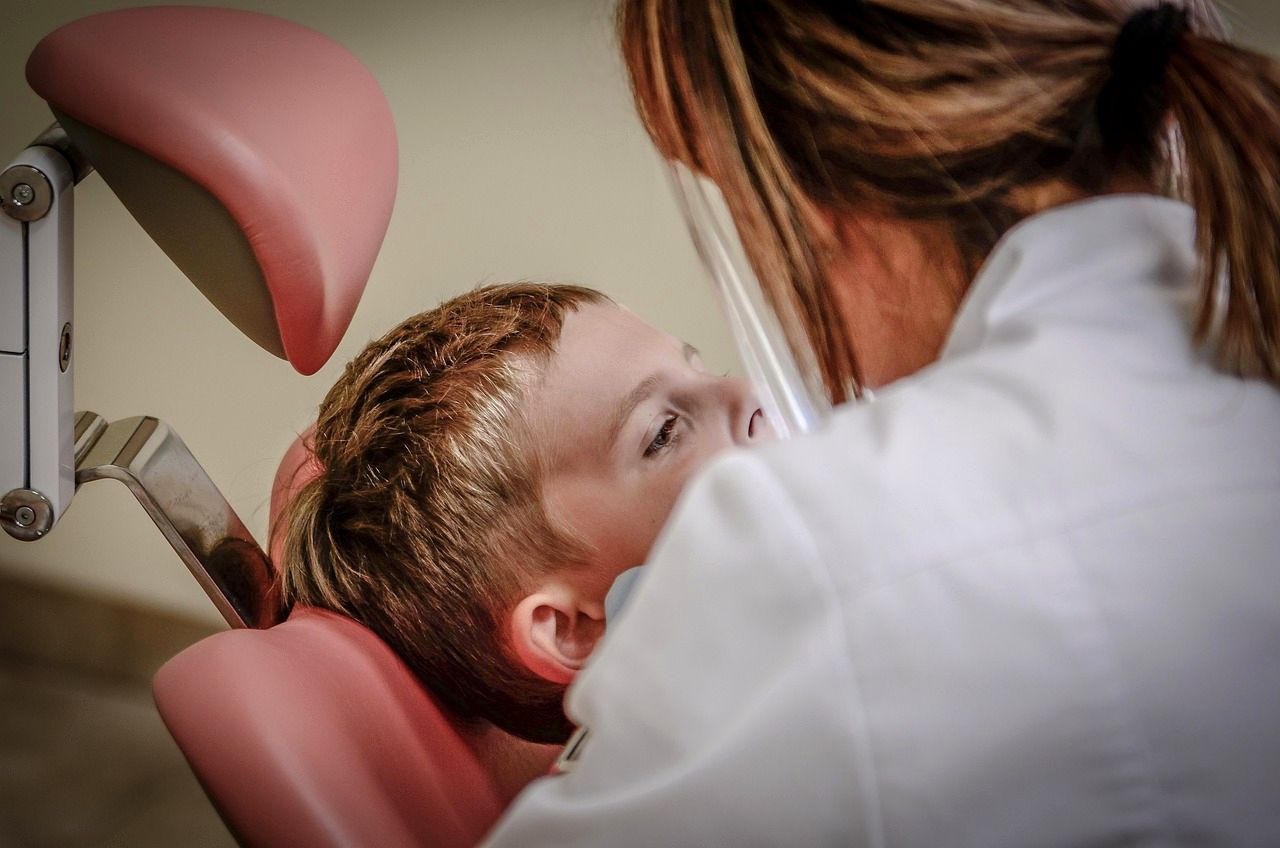 A dentist gently examining a young patient